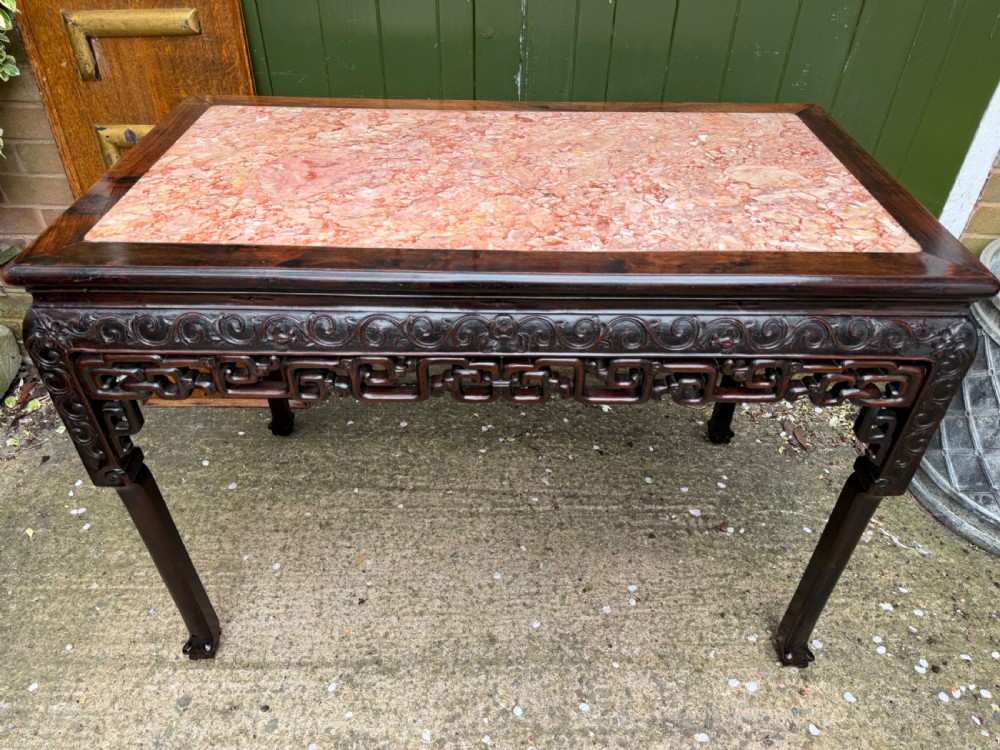 Late 19th-century Chinese Qing Dynasty dark hardwood centre table featuring an inset pink rouge marble rectangular top and intricately carved fretwork aprons. View IV