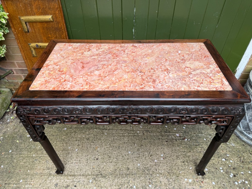 Late 19th-century Chinese Qing Dynasty dark hardwood centre table featuring an inset pink rouge marble rectangular top and intricately carved fretwork aprons. View V