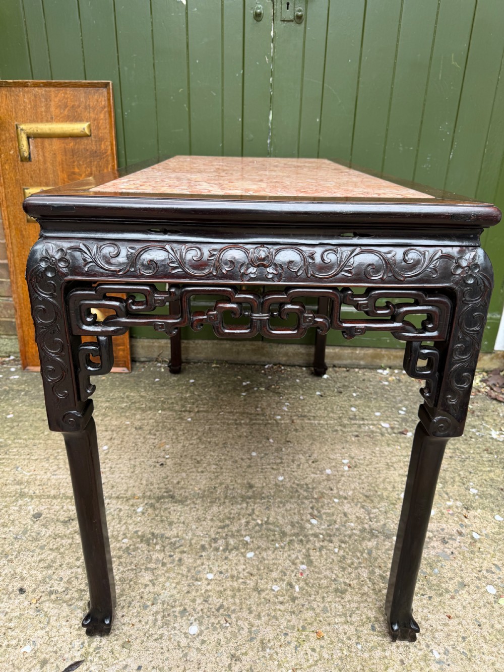 Late 19th-century Chinese Qing Dynasty dark hardwood centre table featuring an inset pink rouge marble rectangular top and intricately carved fretwork aprons. View XVII