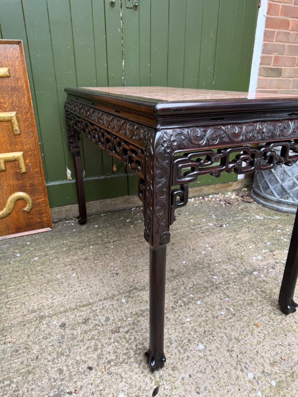 Late 19th-century Chinese Qing Dynasty dark hardwood centre table featuring an inset pink rouge marble rectangular top and intricately carved fretwork aprons. View XIX