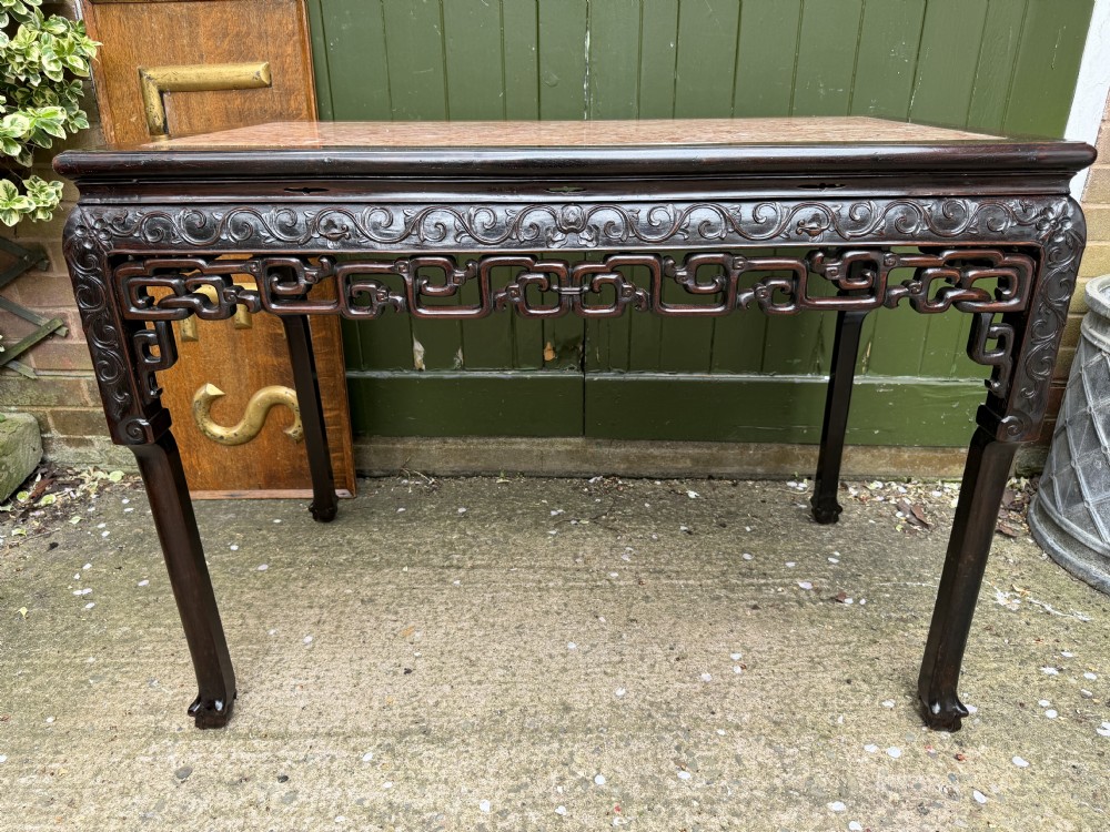 Late 19th-century Chinese Qing Dynasty dark hardwood centre table featuring an inset pink rouge marble rectangular top and intricately carved fretwork aprons. View X