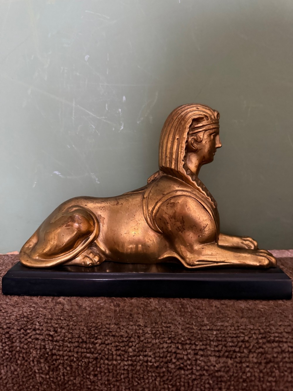 A pair of early nineteenth-century gilded bronze recumbent sphinxes resting on rectangular dark patinated bronze plinth bases. View III