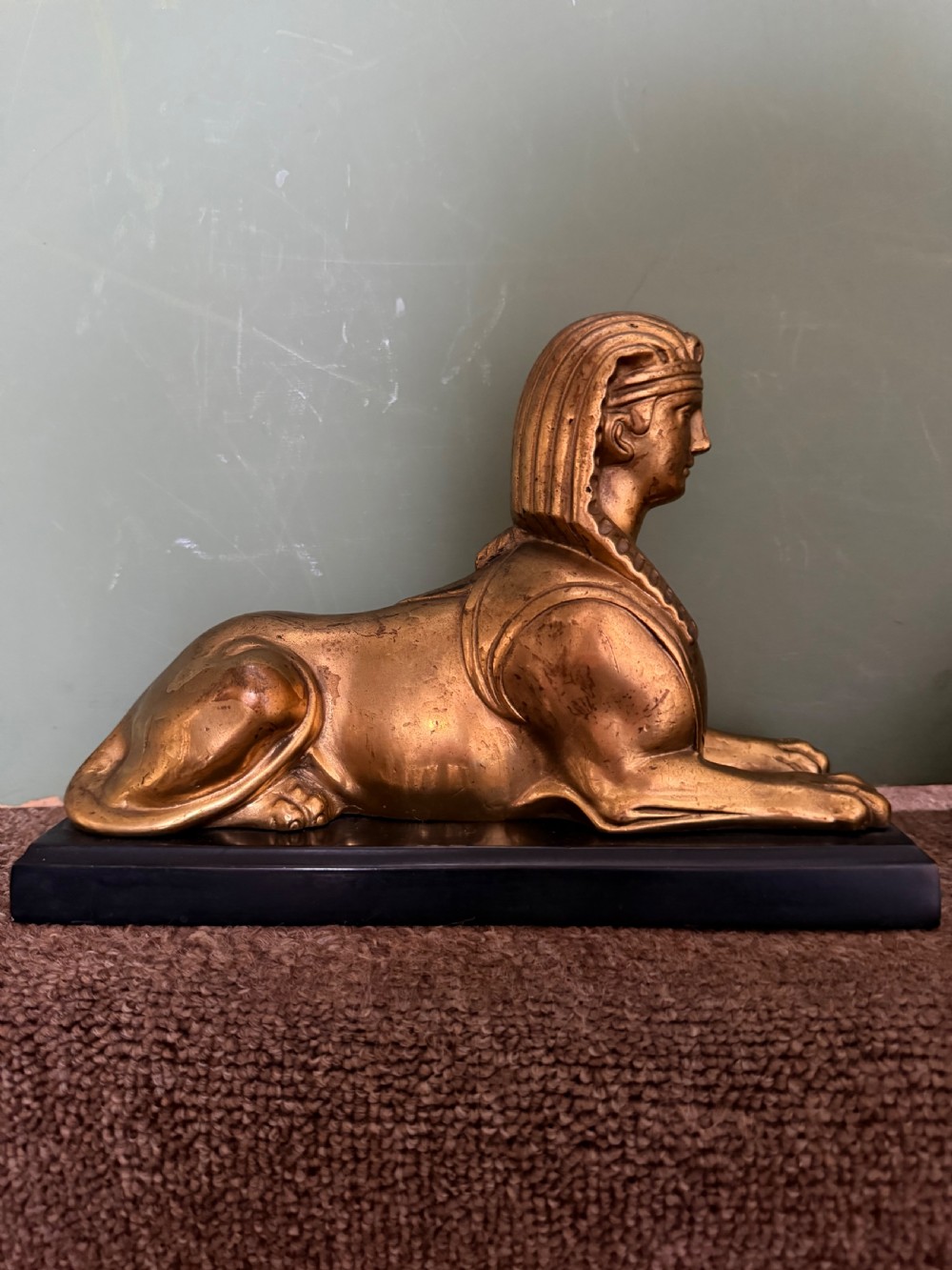A pair of early nineteenth-century gilded bronze recumbent sphinxes resting on rectangular dark patinated bronze plinth bases. View VI