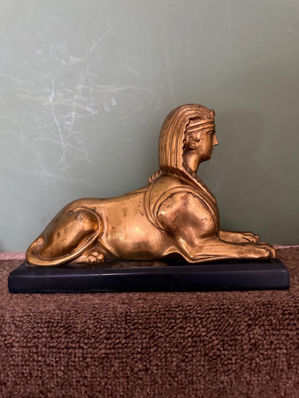 A pair of early nineteenth-century gilded bronze recumbent sphinxes resting on rectangular dark patinated bronze plinth bases. View VII