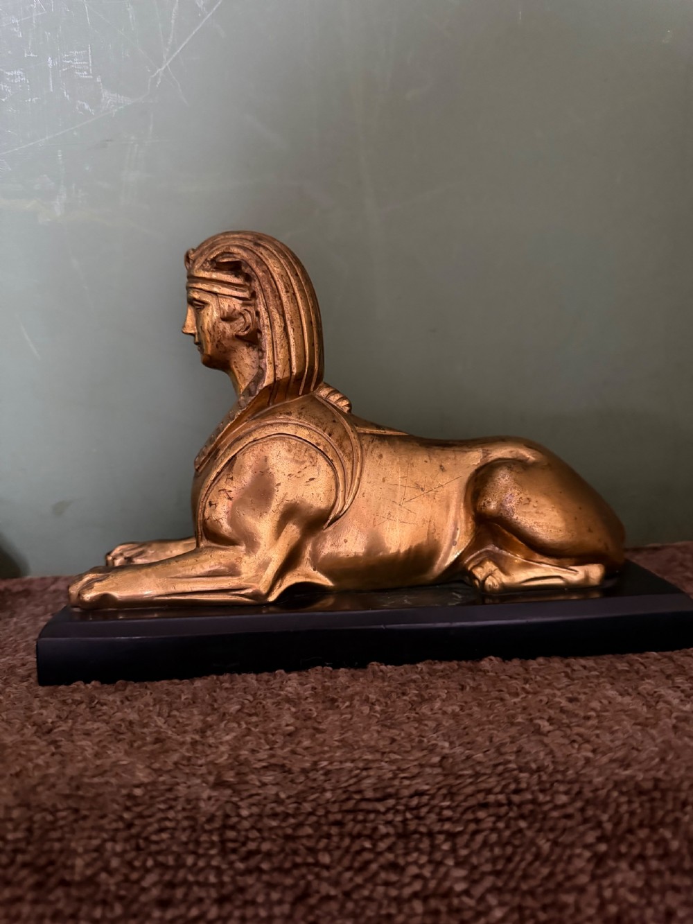 A pair of early nineteenth-century gilded bronze recumbent sphinxes resting on rectangular dark patinated bronze plinth bases. View XIII