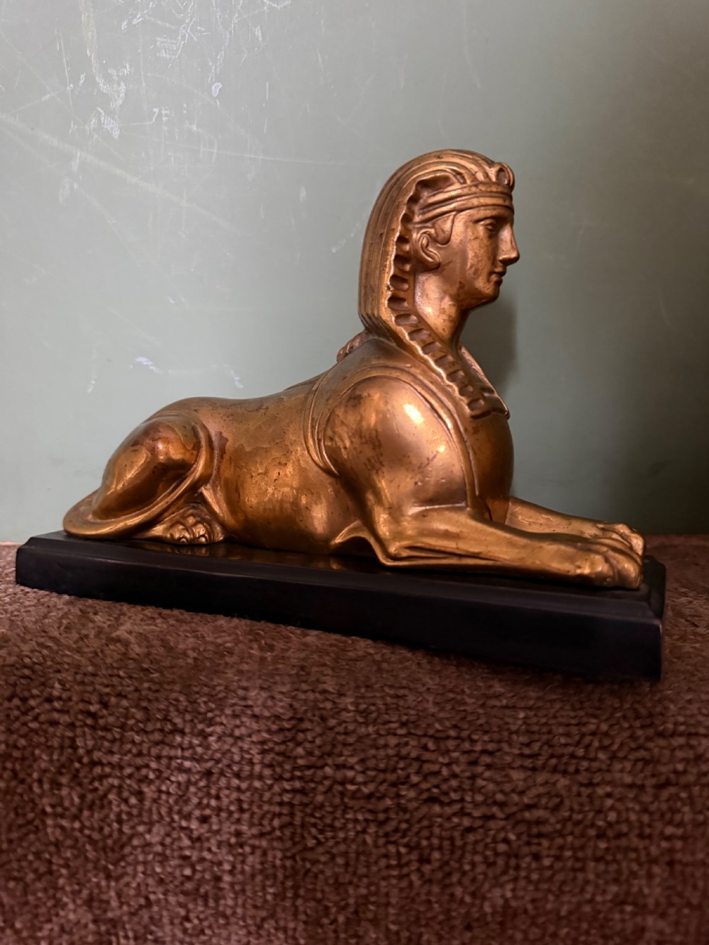 A pair of early nineteenth-century gilded bronze recumbent sphinxes resting on rectangular dark patinated bronze plinth bases. View XVII