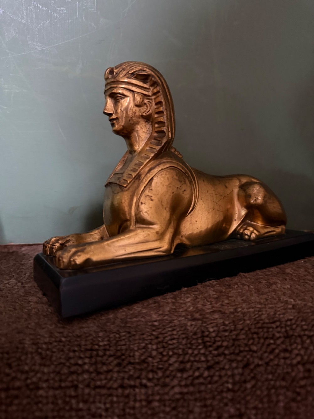 A pair of early nineteenth-century gilded bronze recumbent sphinxes resting on rectangular dark patinated bronze plinth bases. View XVIII