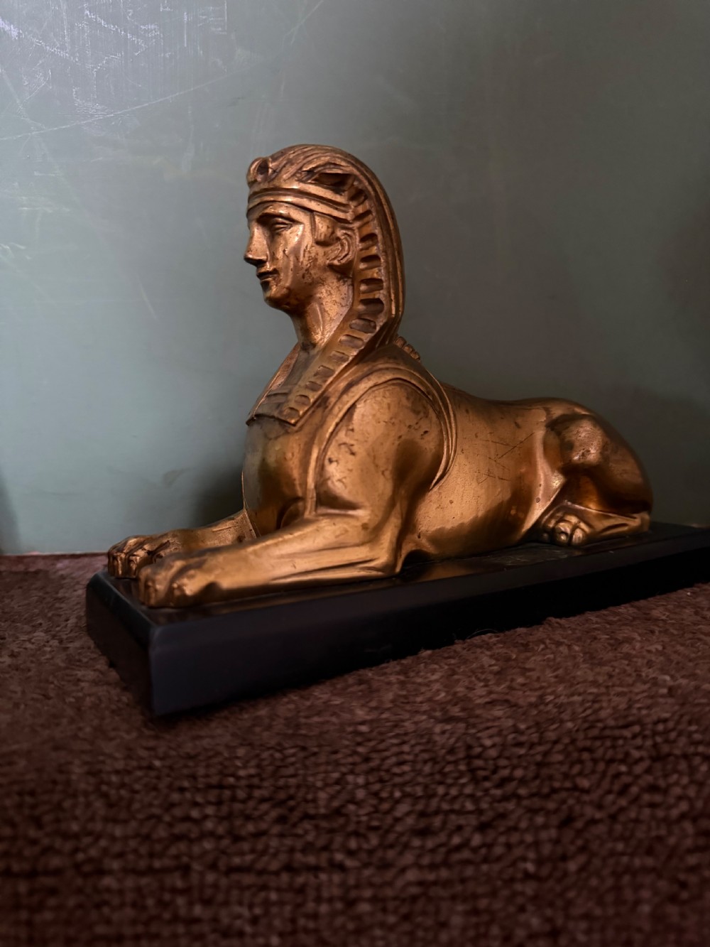 A pair of early nineteenth-century gilded bronze recumbent sphinxes resting on rectangular dark patinated bronze plinth bases. View XIX