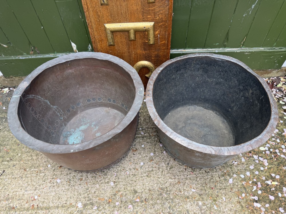 A matched pair of 19th-century copper wash tubs with riveted seams, wide rolled rims, and natural verdigris oxidisation. View XIX