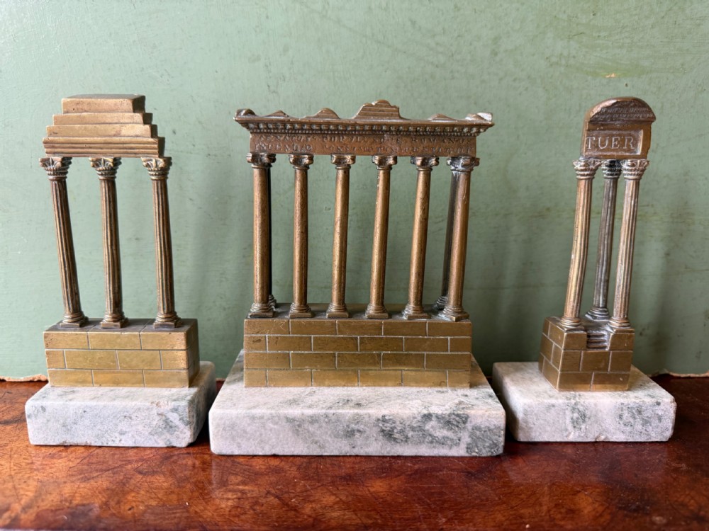 A set of three late 19th-century miniature polished bronze models representing ancient Roman temple ruins mounted on green marble bases. View III