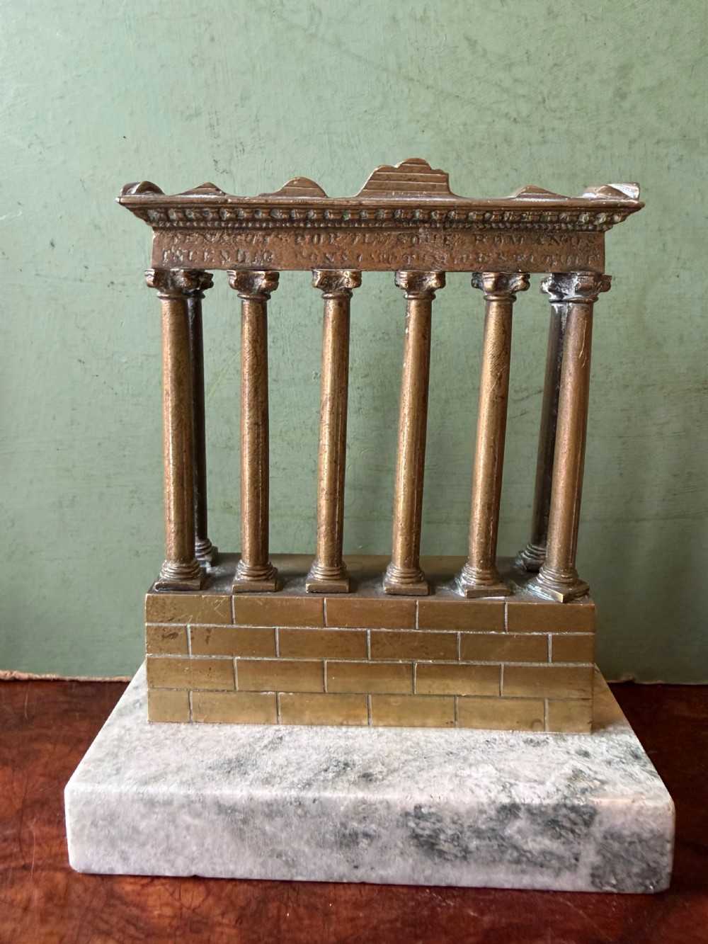 A set of three late 19th-century miniature polished bronze models representing ancient Roman temple ruins mounted on green marble bases. View IV