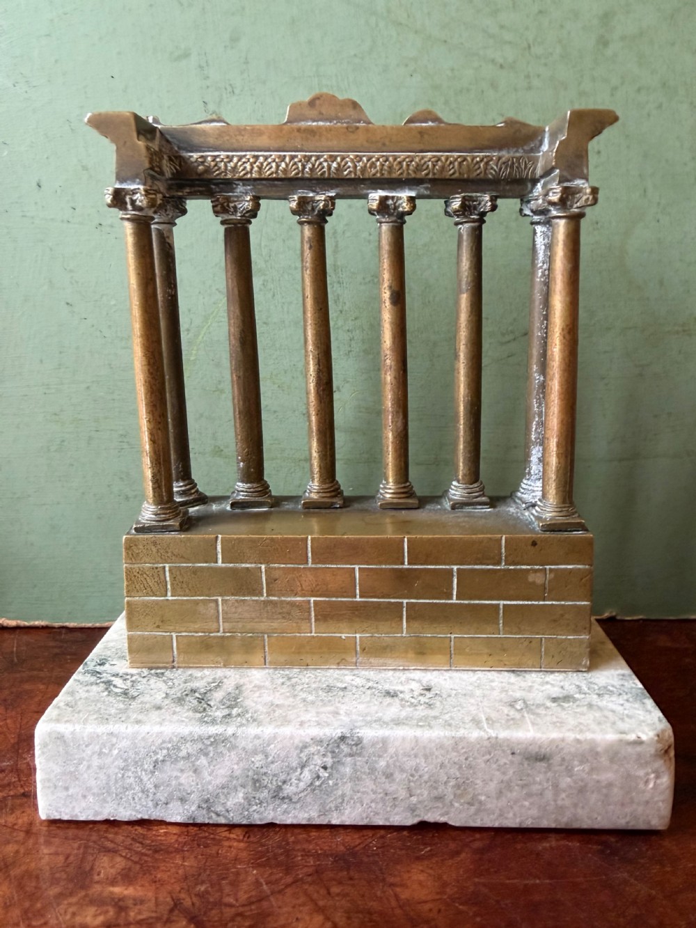 A set of three late 19th-century miniature polished bronze models representing ancient Roman temple ruins mounted on green marble bases. View VI