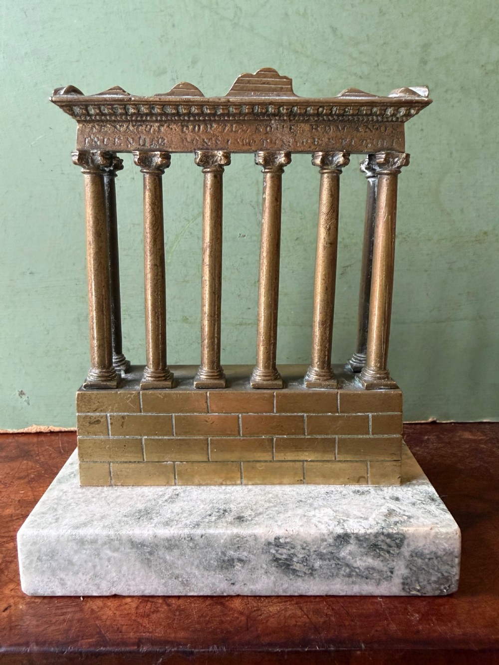 A set of three late 19th-century miniature polished bronze models representing ancient Roman temple ruins mounted on green marble bases. View XII