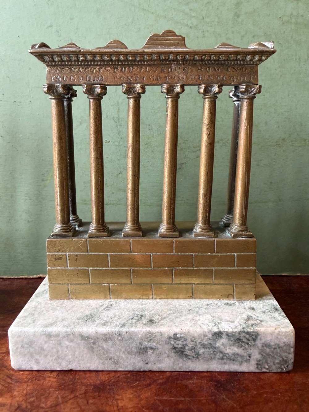 A set of three late 19th-century miniature polished bronze models representing ancient Roman temple ruins mounted on green marble bases. View XV