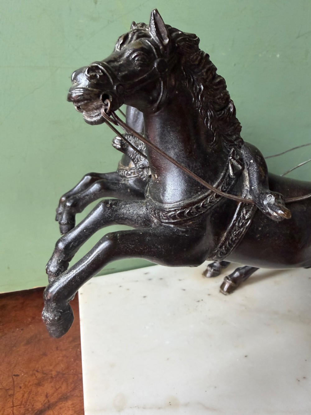 A mid-19th-century dark bronze sculpture depicting a Roman charioteer driving two rearing horses, mounted on a rectangular white marble plinth. View III