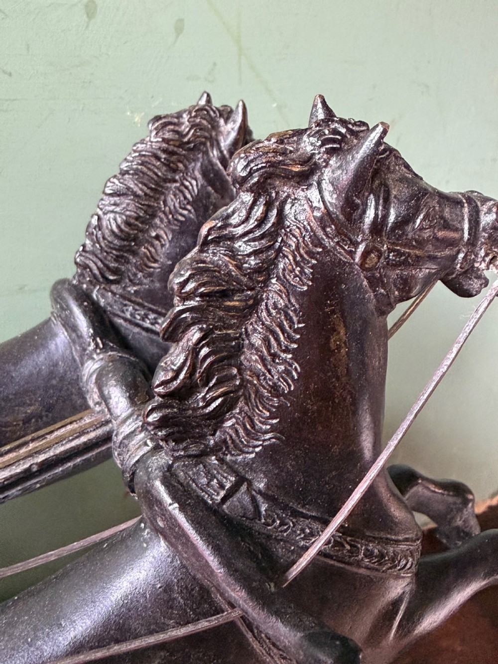 A mid-19th-century dark bronze sculpture depicting a Roman charioteer driving two rearing horses, mounted on a rectangular white marble plinth. View XXII