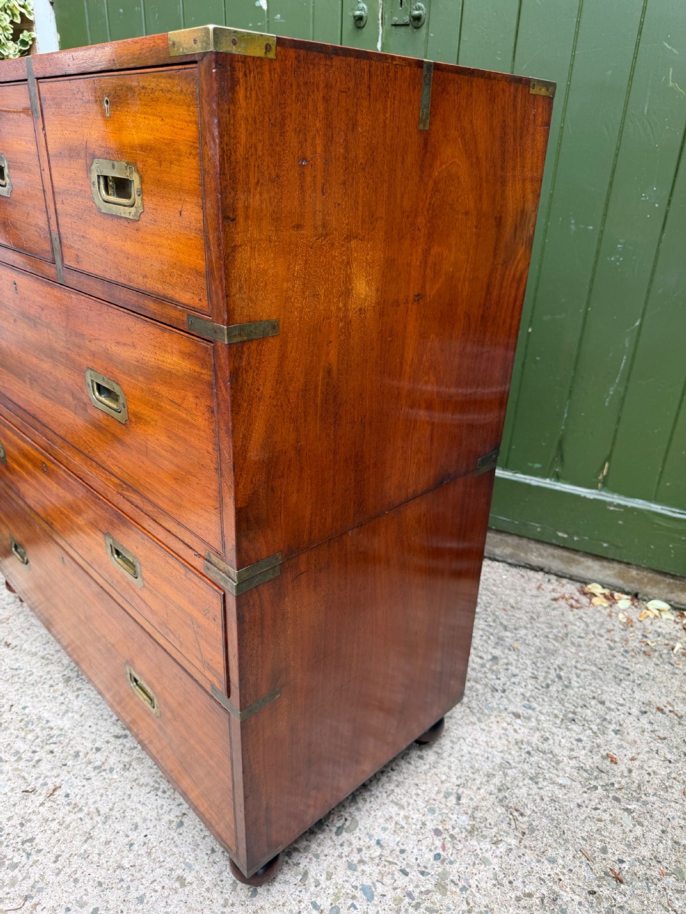 A mid-nineteenth-century mahogany two-part military campaign chest of drawers with flush brass handles, protective brass corners, and turned feet. View XIII