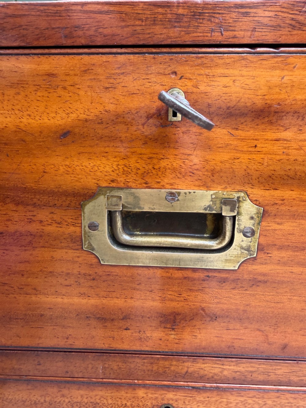 A mid-nineteenth-century mahogany two-part military campaign chest of drawers with flush brass handles, protective brass corners, and turned feet. View XVII