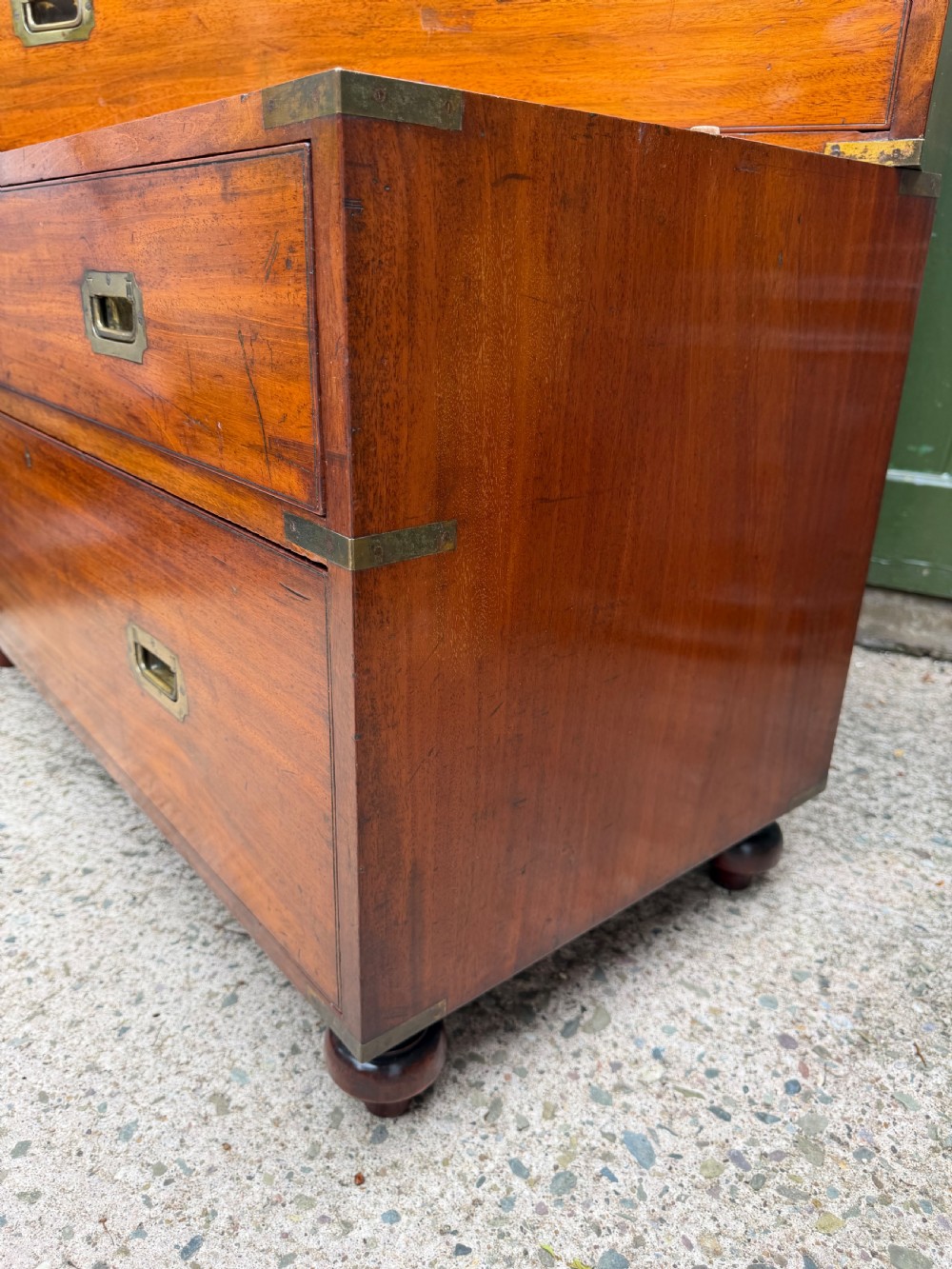 A mid-nineteenth-century mahogany two-part military campaign chest of drawers with flush brass handles, protective brass corners, and turned feet. View XIX