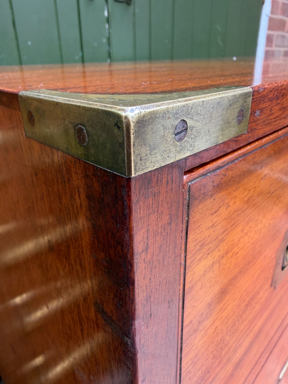 A mid-nineteenth-century mahogany two-part military campaign chest of drawers with flush brass handles, protective brass corners, and turned feet. View XX