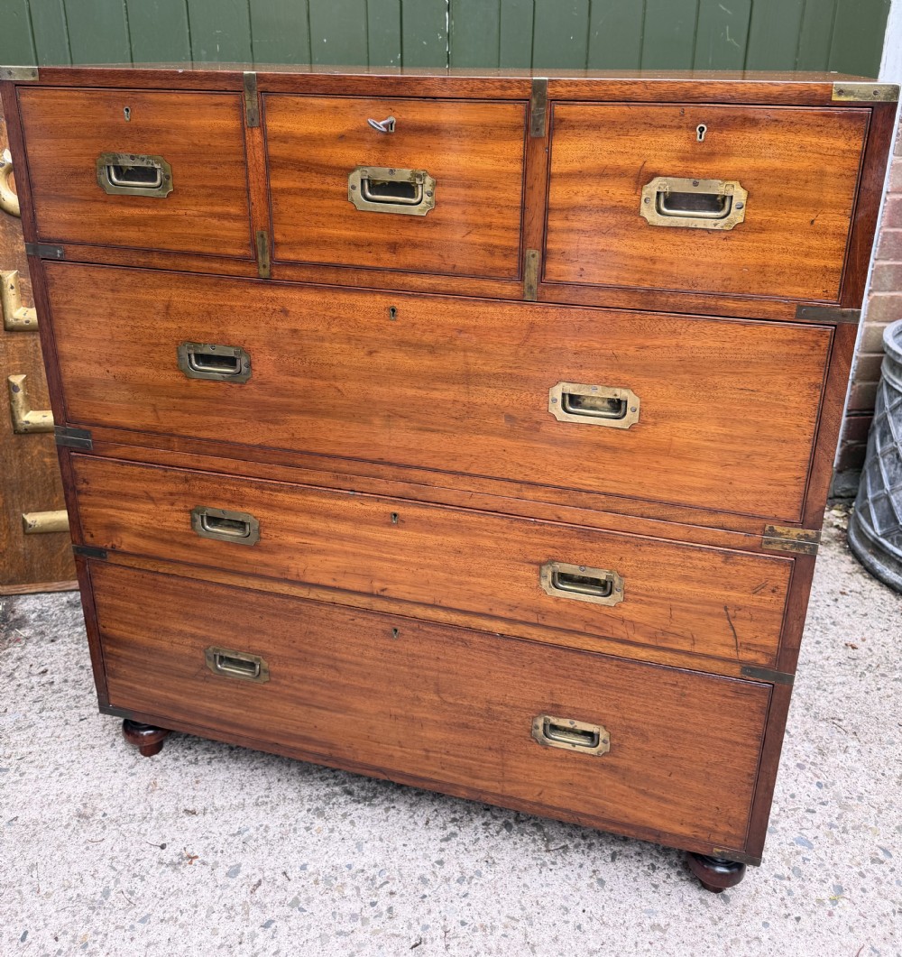 A mid-nineteenth-century mahogany two-part military campaign chest of drawers with flush brass handles, protective brass corners, and turned feet. View V