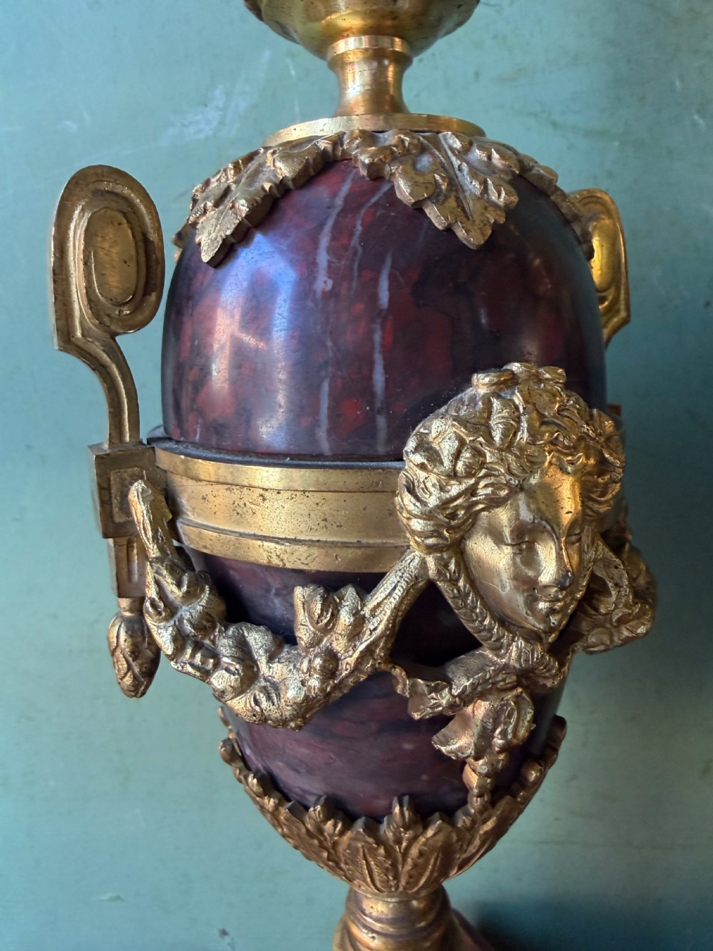 A pair of late nineteenth-century French rouge marble table lamps shaped as urns with gilt bronze mounts and square pedestal bases. View VIII