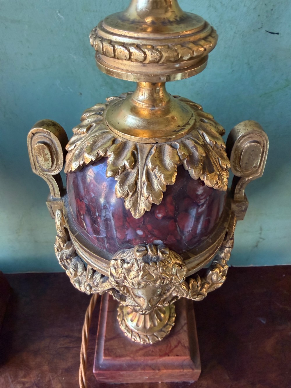 A pair of late nineteenth-century French rouge marble table lamps shaped as urns with gilt bronze mounts and square pedestal bases. View X