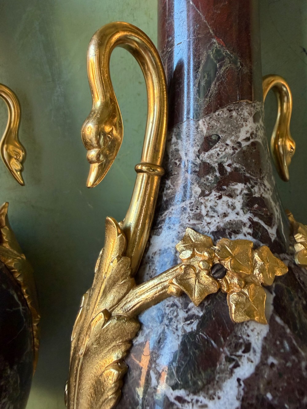 A pair of urn-shaped burgundy marble table lamps featuring gilded bronze swan handles and square pedestals. View VIII