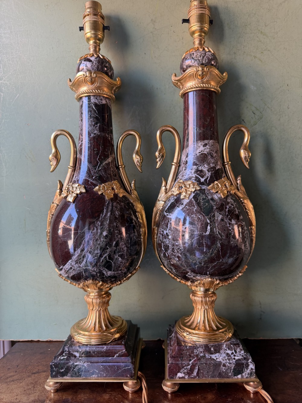 A pair of urn-shaped burgundy marble table lamps featuring gilded bronze swan handles and square pedestals. View XVIII