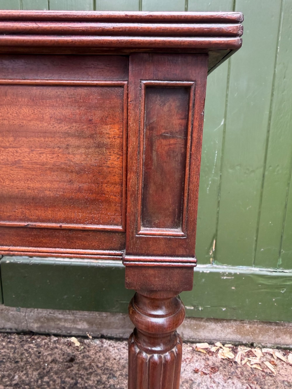 Early 19th-century George IV mahogany writing table featuring a long frieze drawer with brass rosette handles and reeded turned legs on castors. View XIII