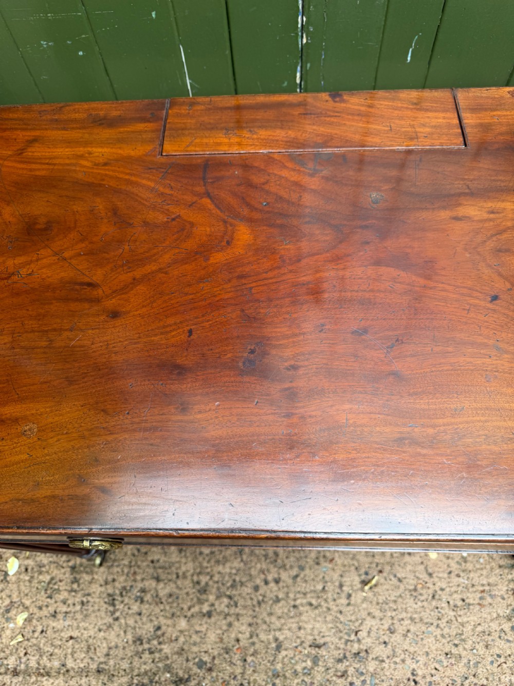 Early 19th-century George IV mahogany writing table featuring a long frieze drawer with brass rosette handles and reeded turned legs on castors. View XXV