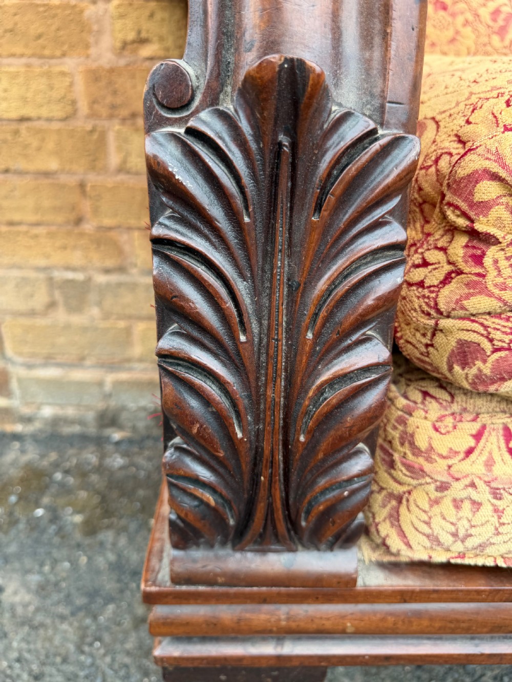 Early 19th-century William IV carved mahogany scroll-end sofa upholstered in red and gold patterned damask with matching bolster cushions. View IV