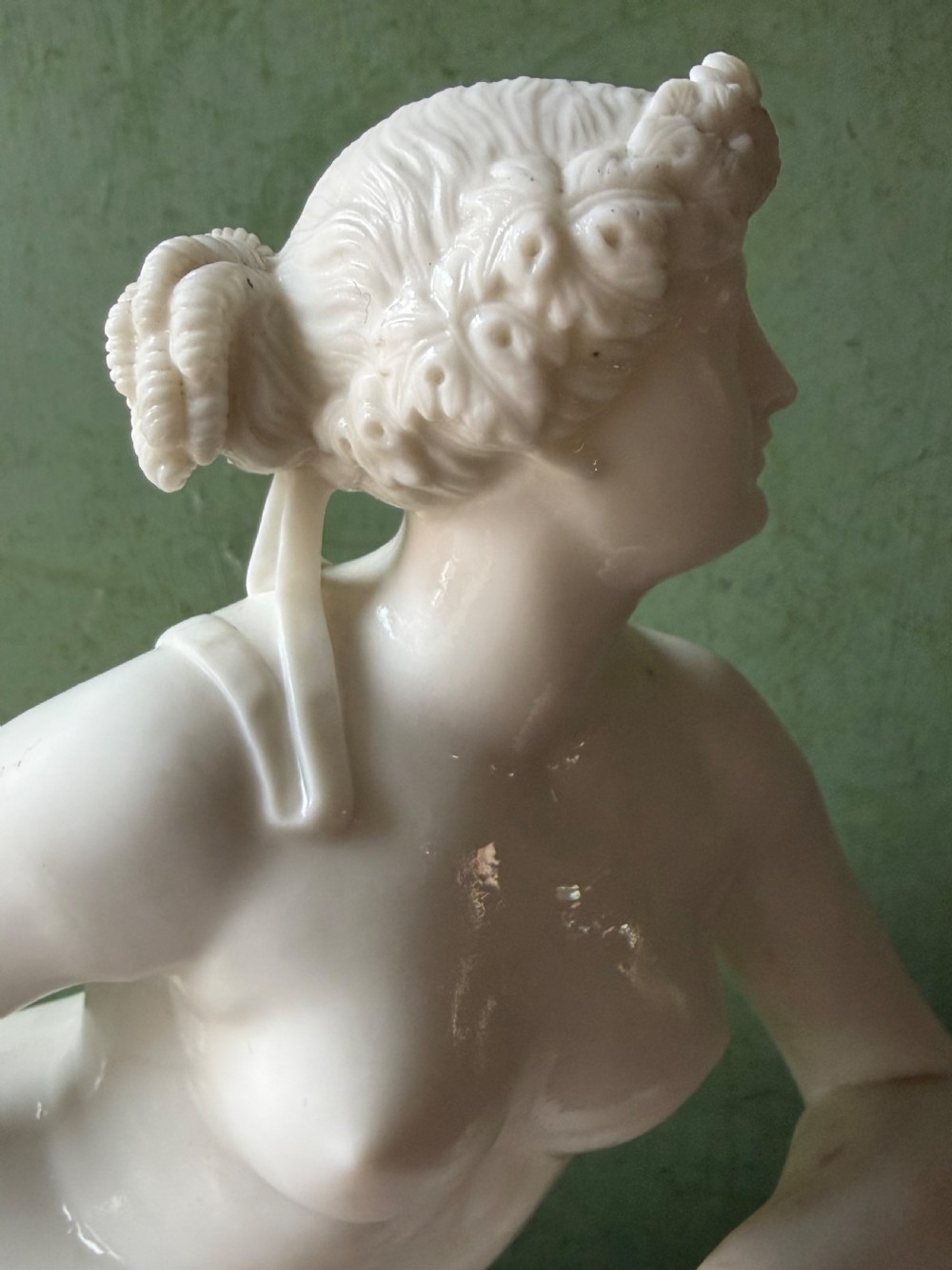 A white Parian porcelain Neoclassical sculpture depicting a reclining female figure mounted on the back of a panther on a rectangular plinth. View II