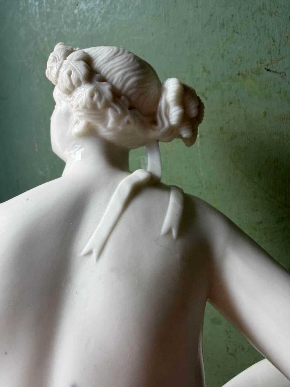 A white Parian porcelain Neoclassical sculpture depicting a reclining female figure mounted on the back of a panther on a rectangular plinth. View X