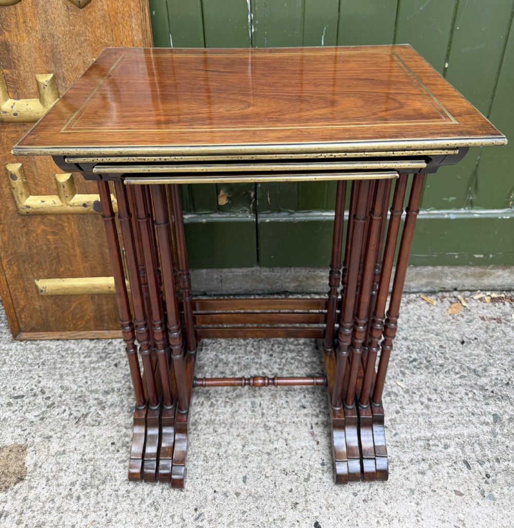 An early nineteenth-century Regency quartetto set of four rosewood nesting tables with brass line inlay and slender turned legs.