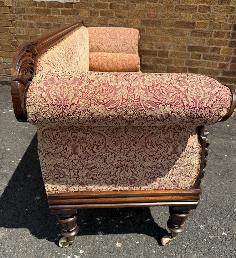 Early 19th-century William IV carved mahogany scroll-end sofa upholstered in red and gold patterned damask with matching bolster cushions. View XX