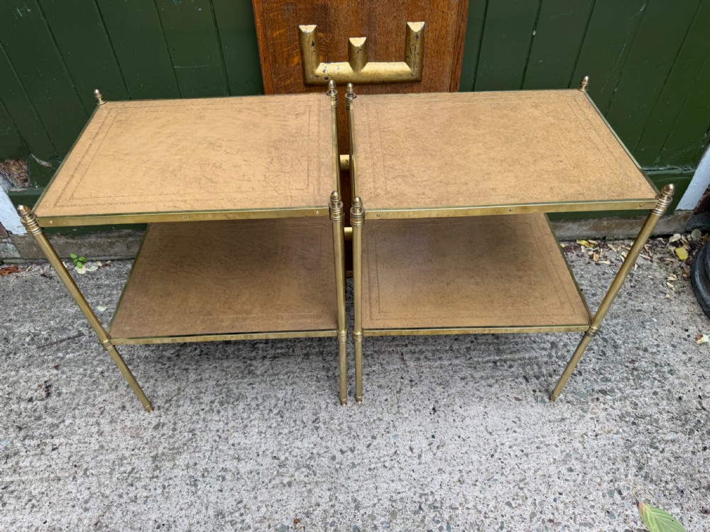 A pair of early twentieth-century two-tier lacquered brass etagere tables featuring inset tan tooled leather tops and turned brass corner posts. View IV