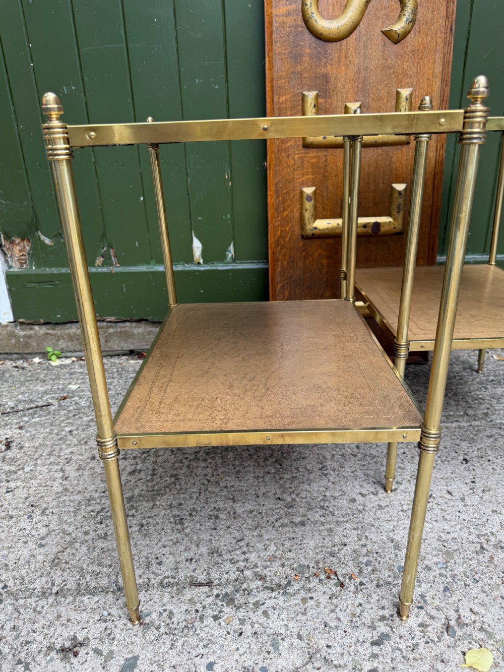 A pair of early twentieth-century two-tier lacquered brass etagere tables featuring inset tan tooled leather tops and turned brass corner posts. View IX