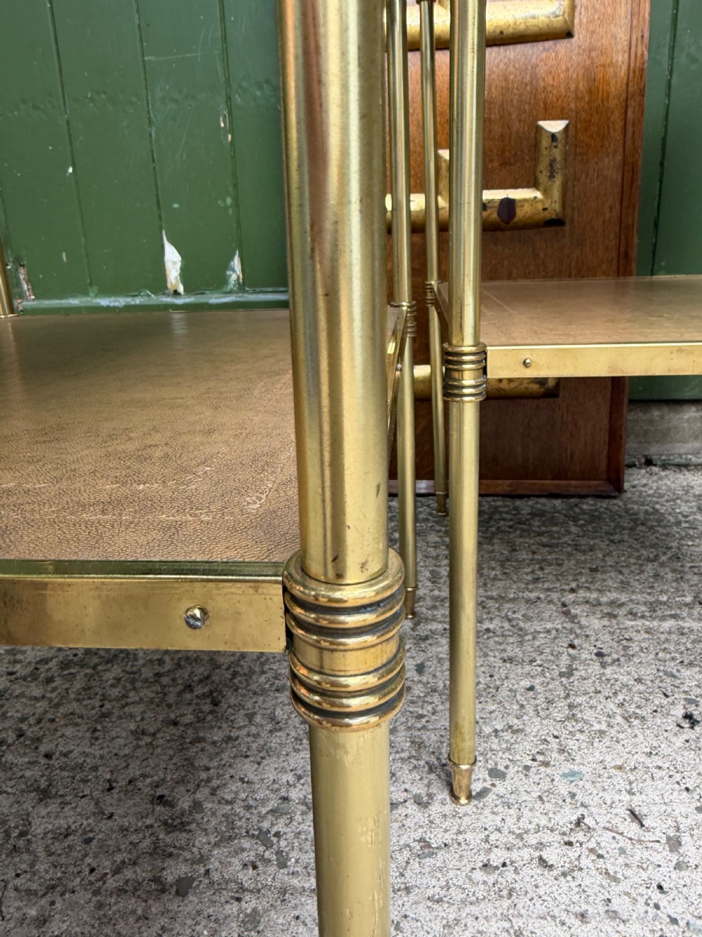 A pair of early twentieth-century two-tier lacquered brass etagere tables featuring inset tan tooled leather tops and turned brass corner posts. View XI