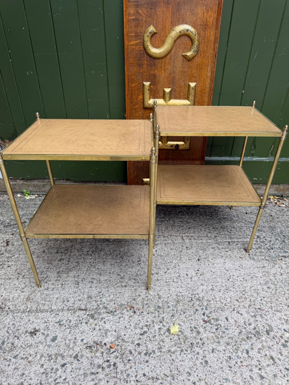 A pair of early twentieth-century two-tier lacquered brass etagere tables featuring inset tan tooled leather tops and turned brass corner posts. View XV