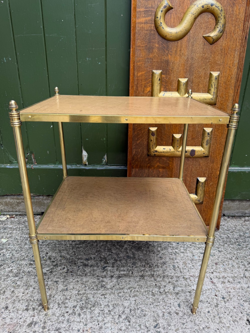 A pair of early twentieth-century two-tier lacquered brass etagere tables featuring inset tan tooled leather tops and turned brass corner posts. View XVI