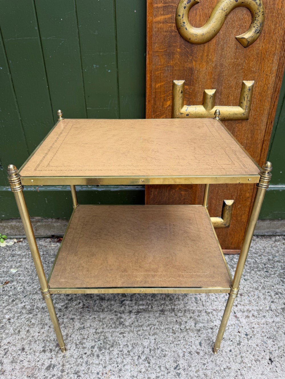 A pair of early twentieth-century two-tier lacquered brass etagere tables featuring inset tan tooled leather tops and turned brass corner posts. View XVII