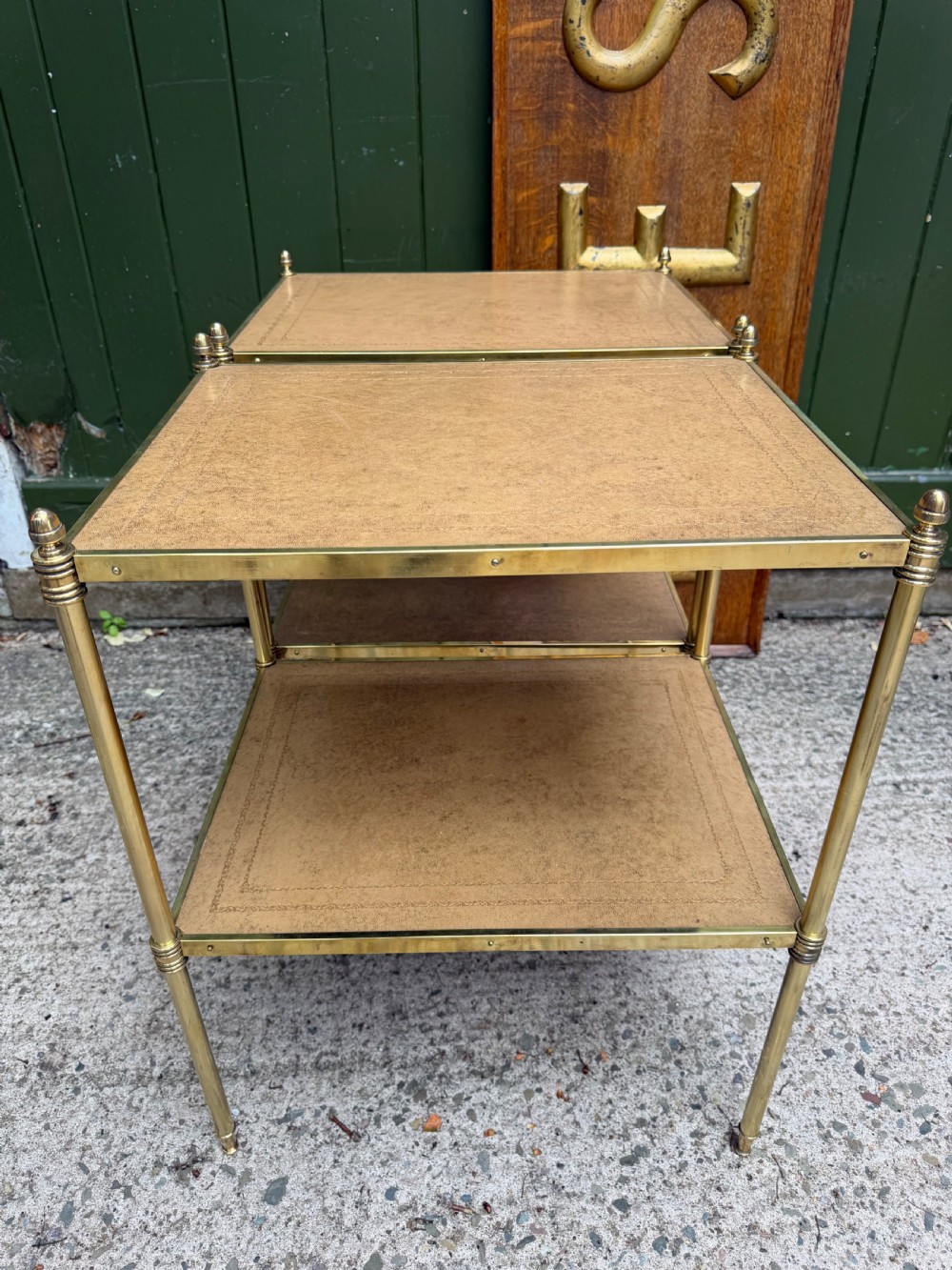 A pair of early twentieth-century two-tier lacquered brass etagere tables featuring inset tan tooled leather tops and turned brass corner posts. View XIX