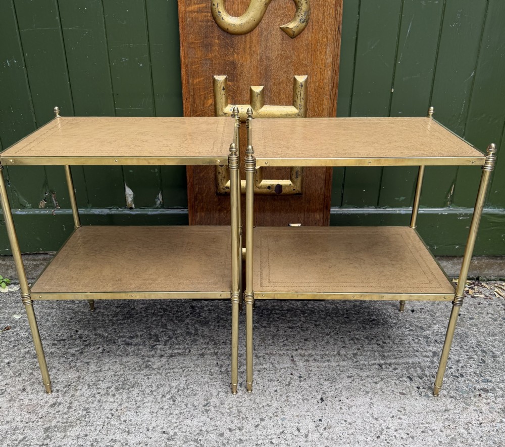 A pair of early twentieth-century two-tier lacquered brass etagere tables featuring inset tan tooled leather tops and turned brass corner posts. View XXI