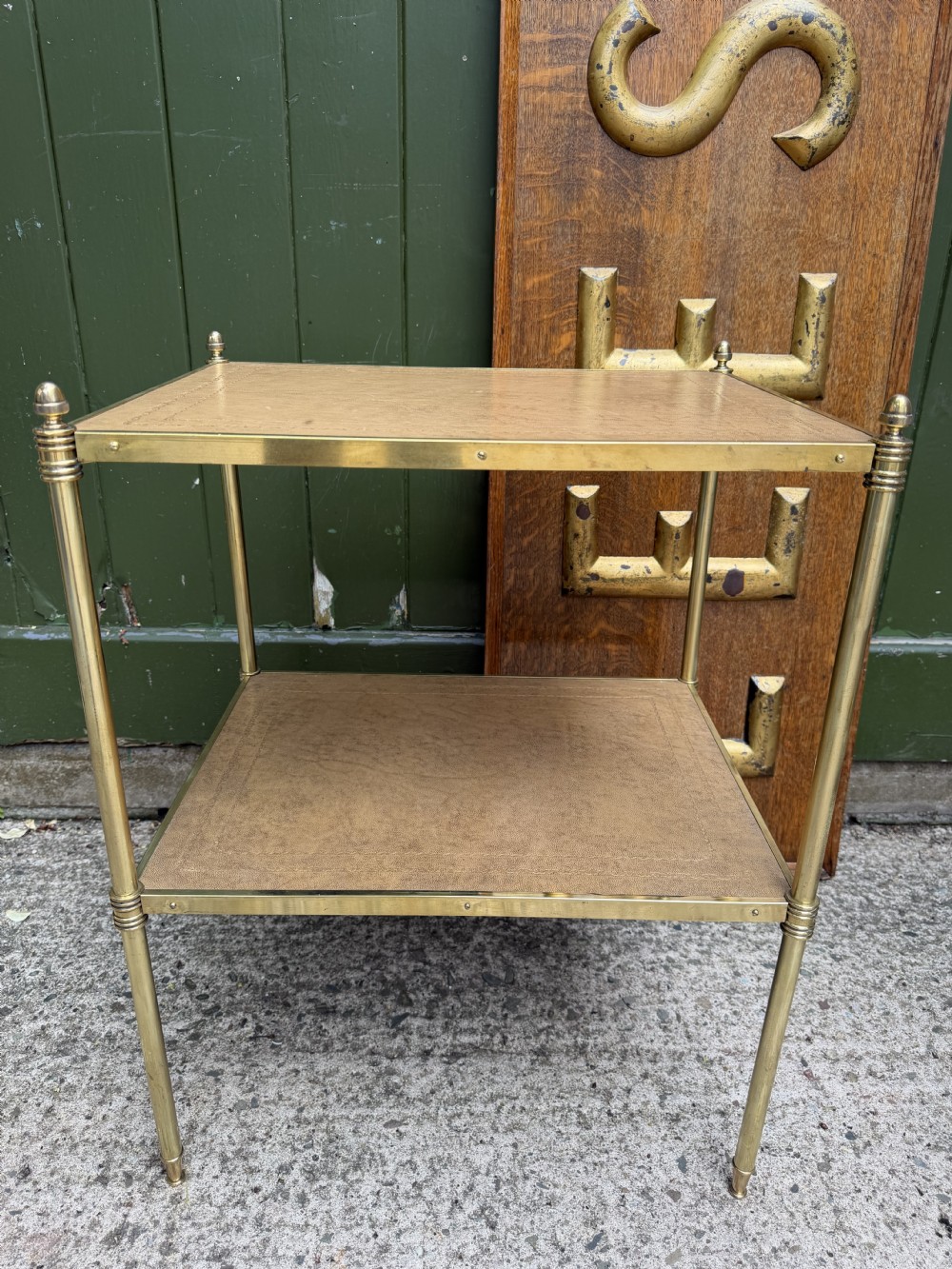 A pair of early twentieth-century two-tier lacquered brass etagere tables featuring inset tan tooled leather tops and turned brass corner posts. View XXIII