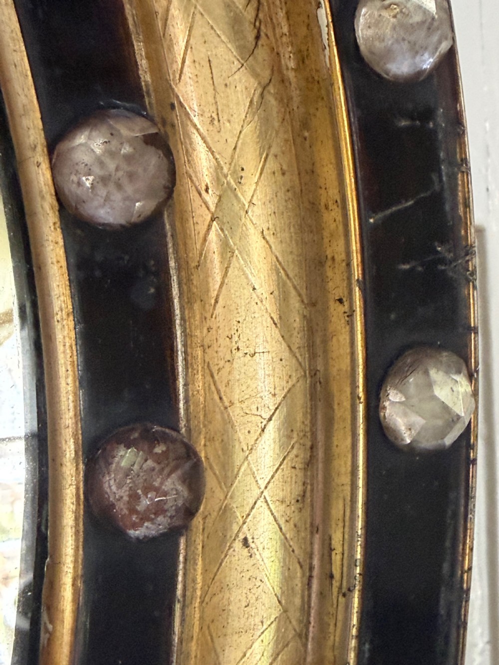 Scarce pair of early C19th Irish oval ebonised , parcel-gilt and glass cabochon mounted mirrors of smaller scale . View III