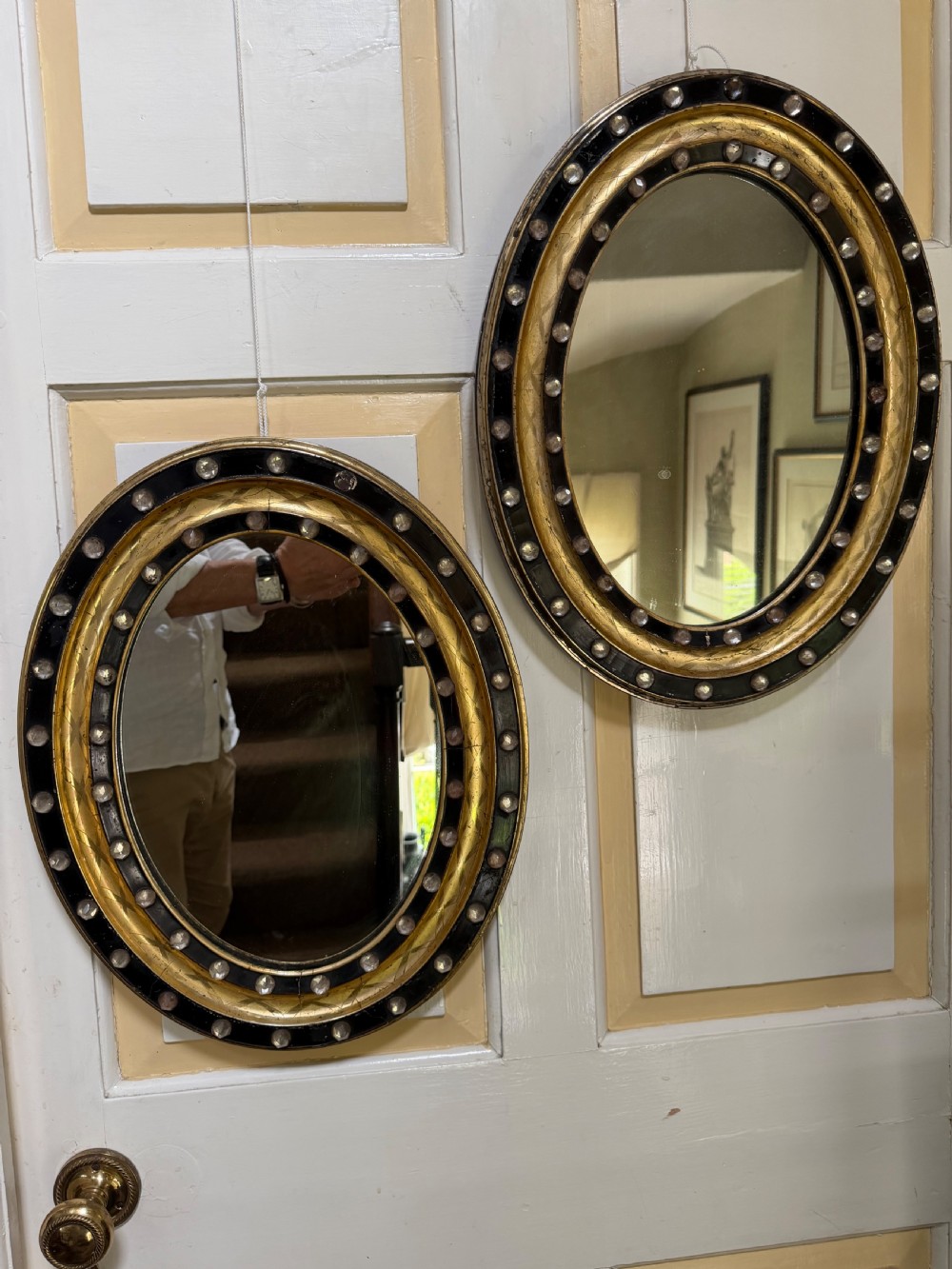 Scarce pair of early C19th Irish oval ebonised , parcel-gilt and glass cabochon mounted mirrors of smaller scale . View IV