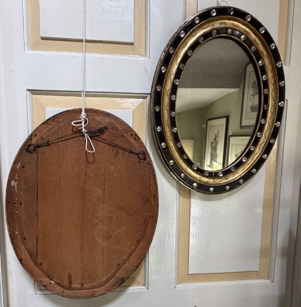 Scarce pair of early C19th Irish oval ebonised , parcel-gilt and glass cabochon mounted mirrors of smaller scale . View IX