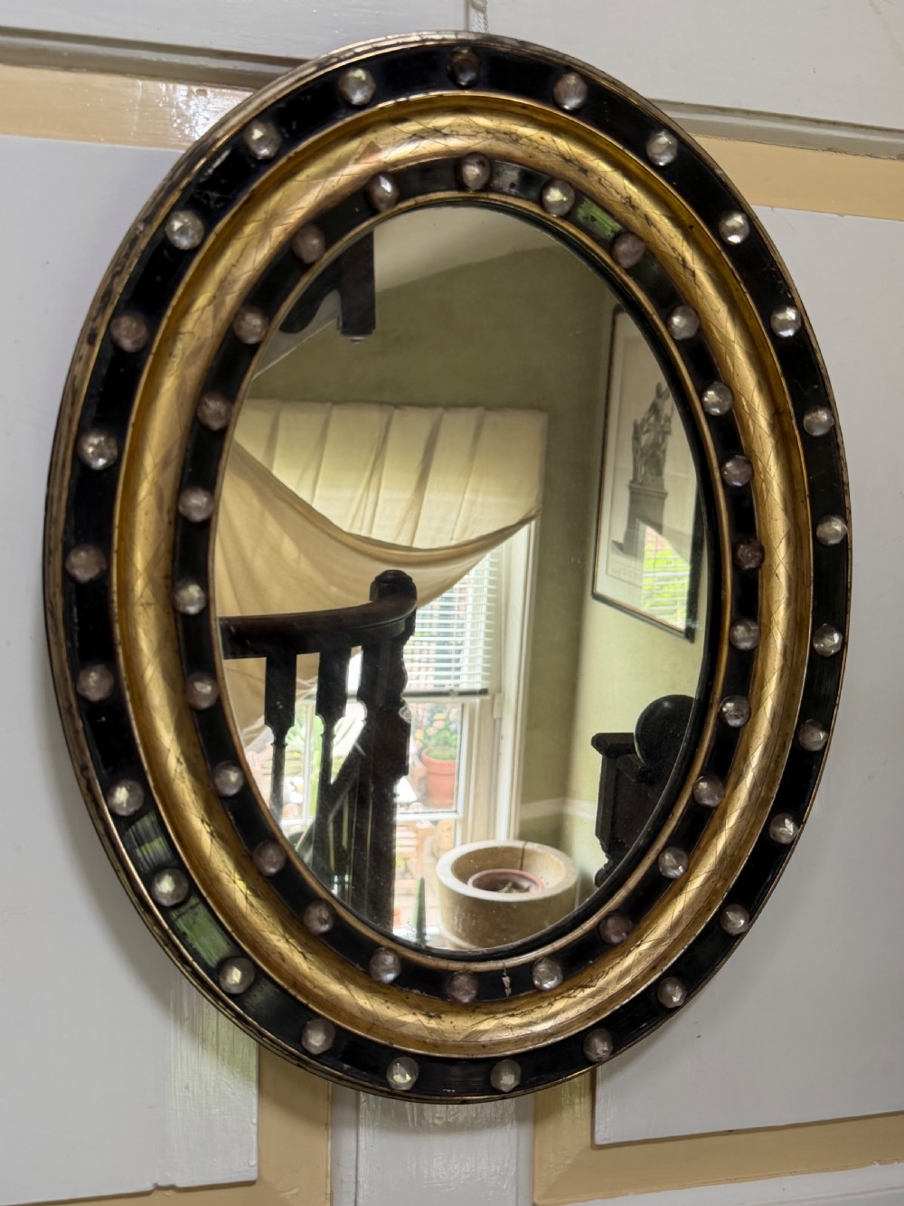 Scarce pair of early C19th Irish oval ebonised , parcel-gilt and glass cabochon mounted mirrors of smaller scale . View XIV