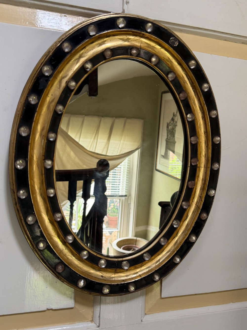 Scarce pair of early C19th Irish oval ebonised , parcel-gilt and glass cabochon mounted mirrors of smaller scale . View XV